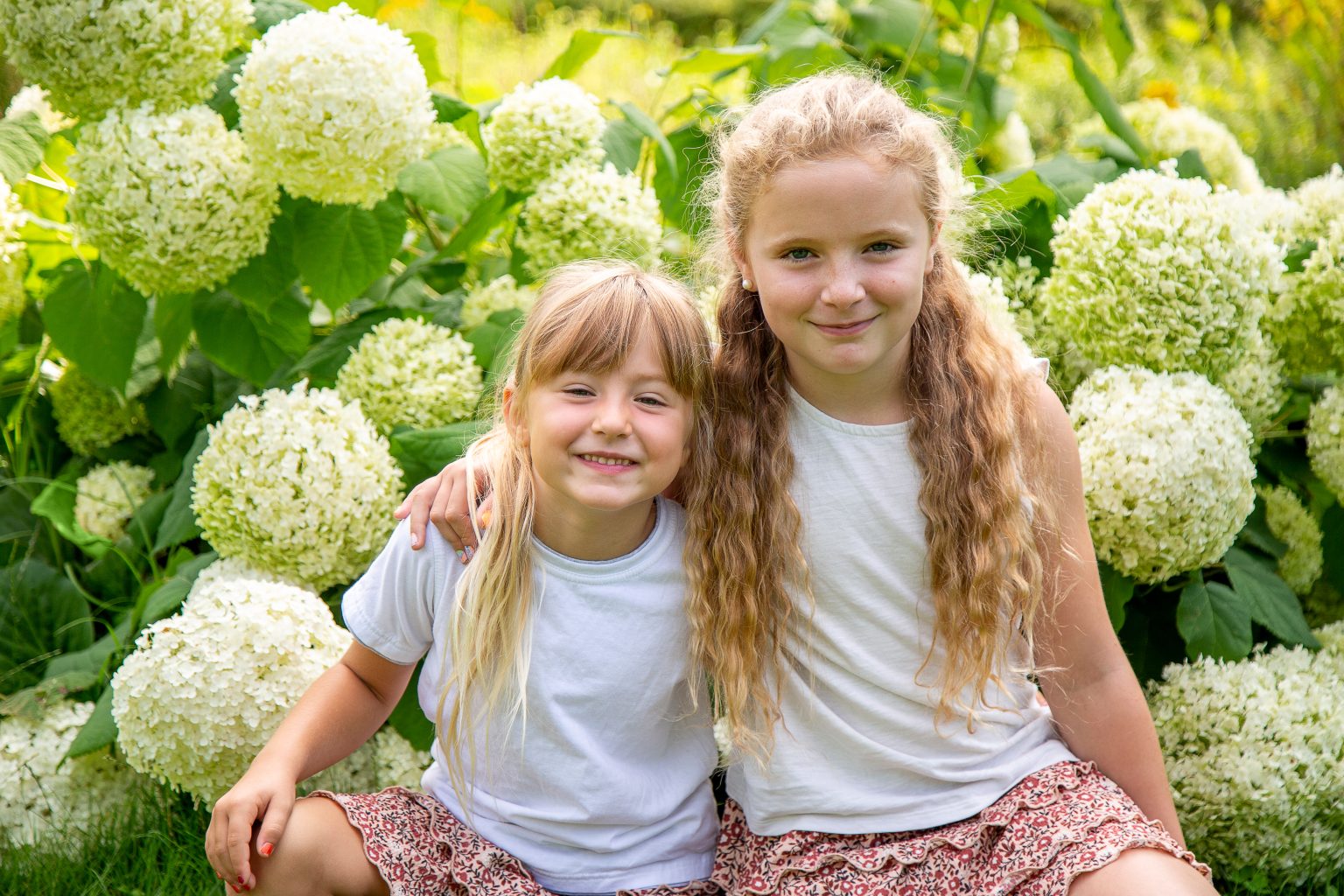 Familienfoto Geschwister – Sarah Seiler Fotografie Zwei Kinder sitzen draußen zusammen und Sarah Seiler Fotografie hält diesen Moment fest.