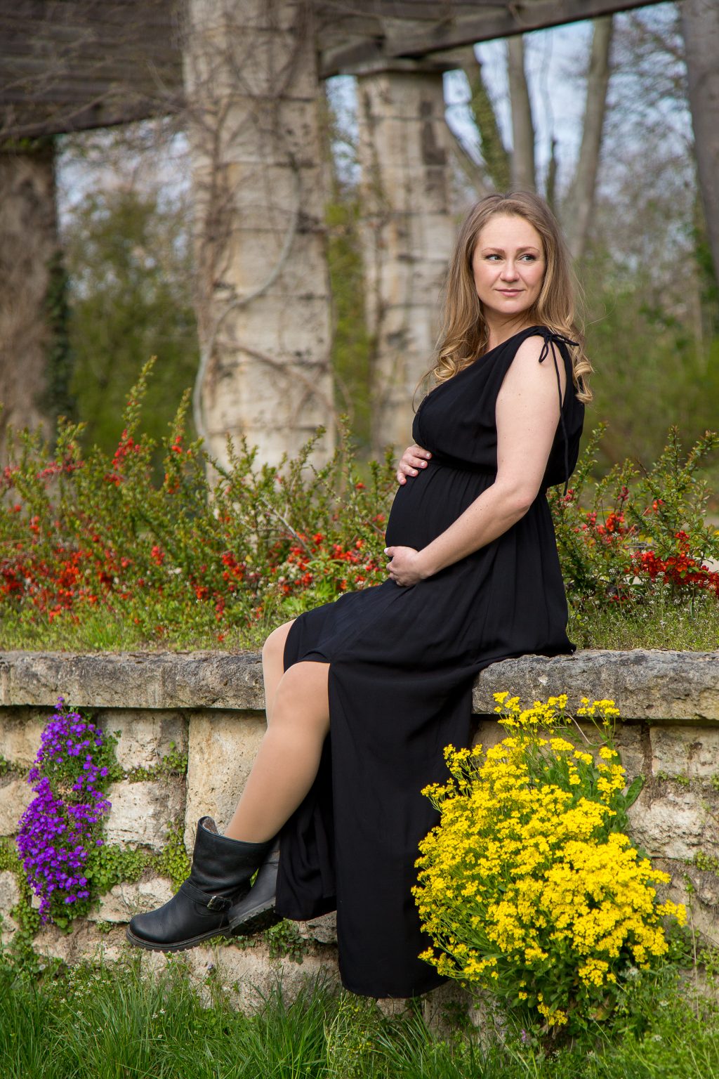 Sarah Seiler Fotografie Eine schwangere Frau sitzt draußen und Sarah Seiler Fotografie fotografiert sie.