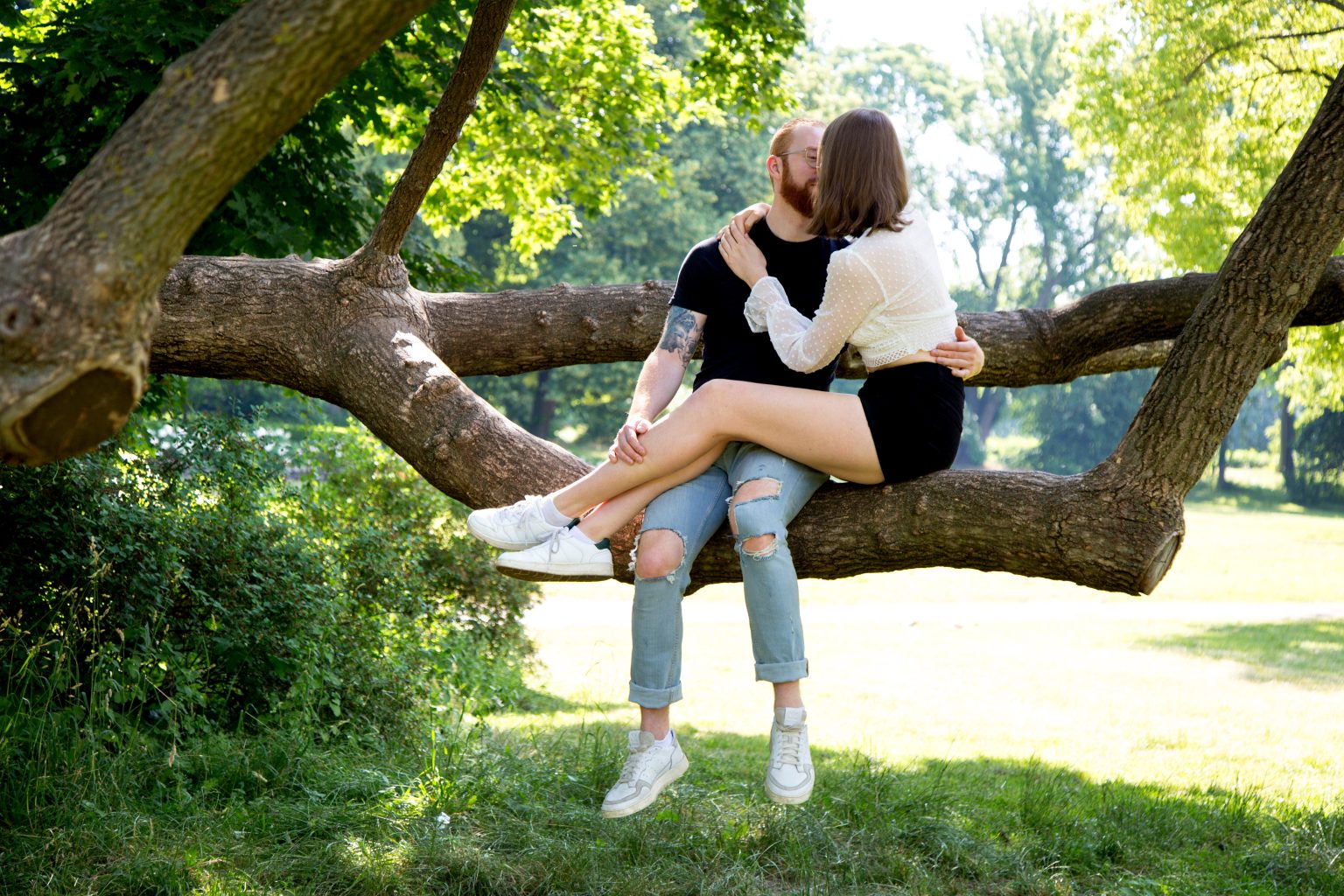 Paarshooting von Sarah Seiler Fotografie Ein Paar sitzt auf einem Baumstamm und Sarah Seiler Fotografie hält diesen Moment fest.