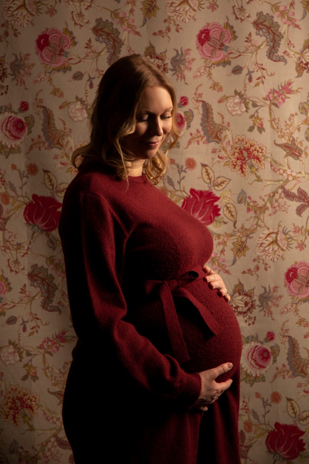 Sarah Seiler Fotografie Eine schwangere Frau hält ihren Babybauch und Sarah Seiler Fotografie fotografiert sie.