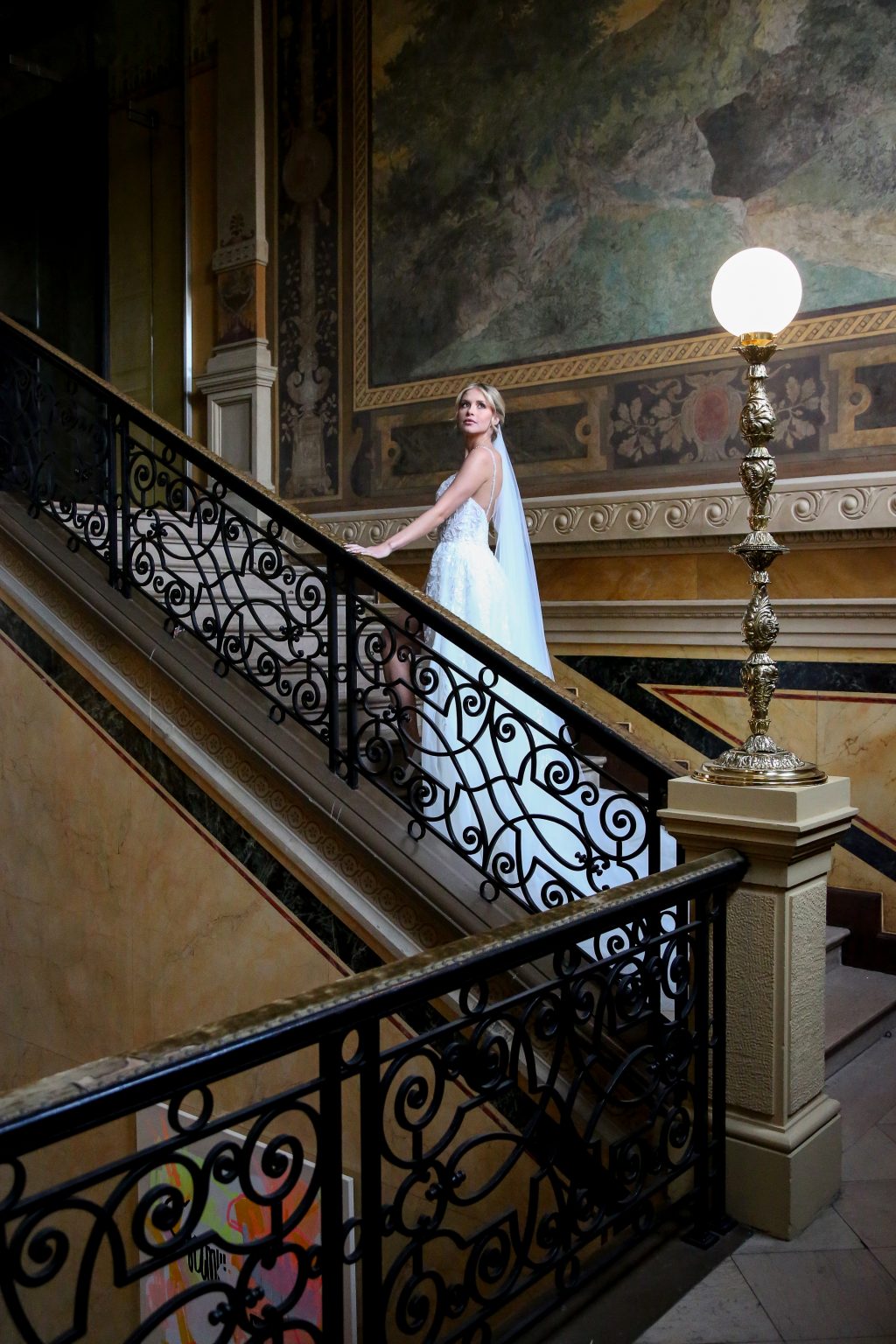 Hochzeitsfoto von Sarah Seiler Fotografie Eine Braut steigt eine große Treppe hinunter und Sarah Seiler Fotografie hält diesen Moment fest.