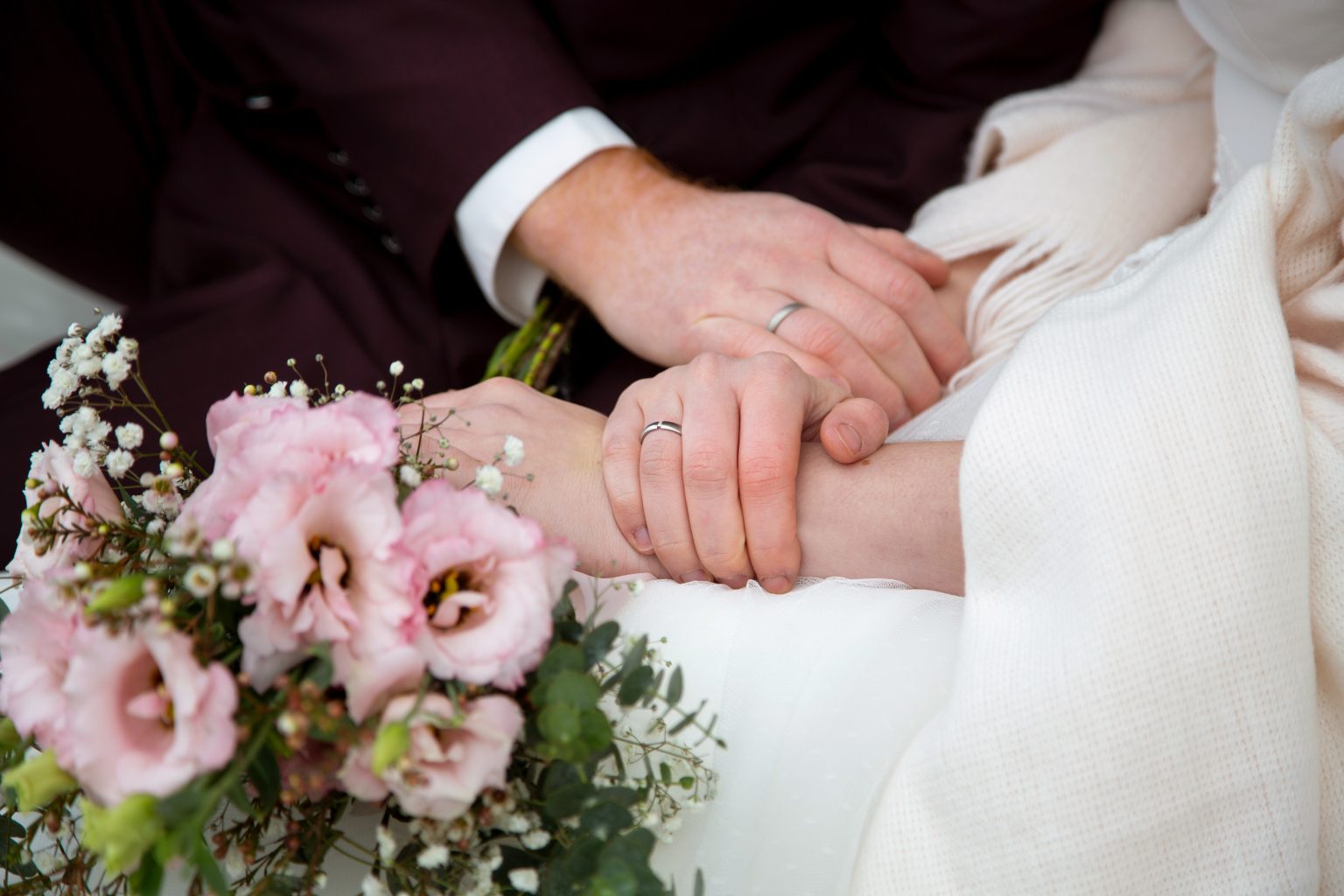 Hochzeitsfoto von Sarah Seiler Fotografie Ein Hochzeitspaar hält sich an den Händen und Sarah Seiler Fotografie fotografiert die Ringe.