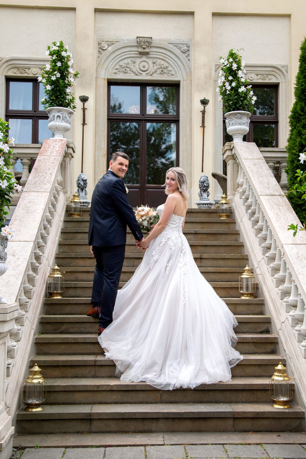 Hochzeitsfoto von Sarah Seiler Fotografie Ein Hochzeitspaar steht elegant auf einer Treppe und Sarah Seiler Fotografie hält diesen Moment fest.