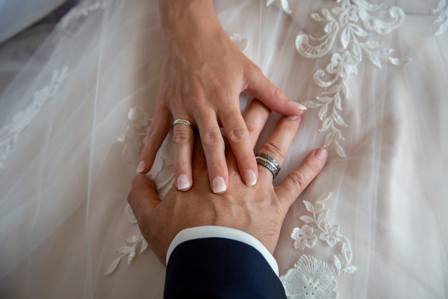 Hochzeitsfoto von Sarah Seiler Fotografie Zwei Hände mit frisch angelegten Eheringen werden von Sarah Seiler Fotografie festgehalten.