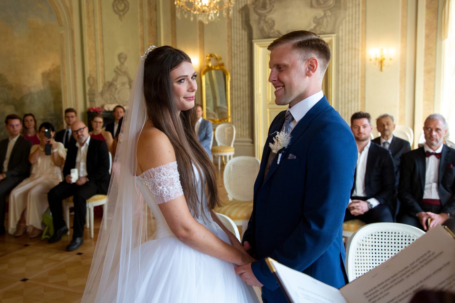 Hochzeitsfoto von Sarah Seiler Fotografie Eine Braut und ein Bräutigam stehen in einem Festsaal und Sarah Seiler Fotografie fotografiert sie.