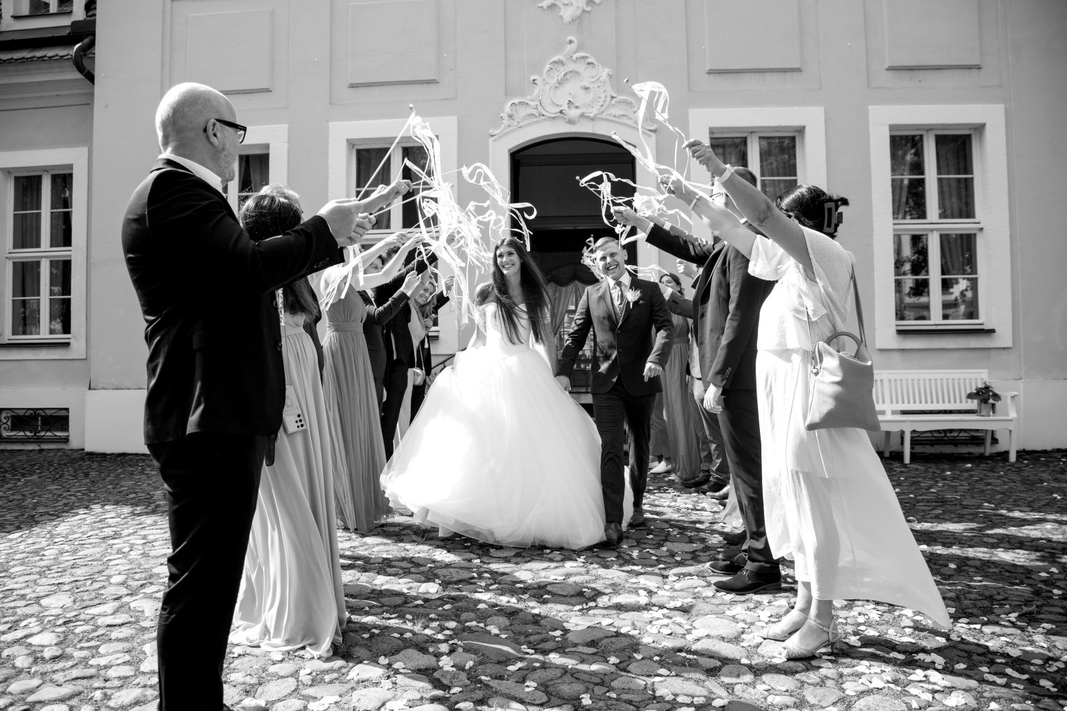 Hochzeitsfoto von Sarah Seiler Fotografie Ein Hochzeitspaar läuft durch ein Spalier und Sarah Seiler Fotografie hält den Moment fest.