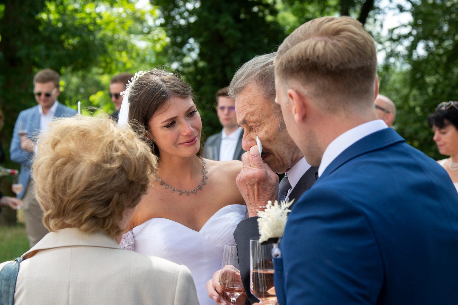 Familienfoto von Sarah Seiler Fotografie Eine Braut spricht mit Hochzeitsgästen und Sarah Seiler Fotografie fotografiert sie.