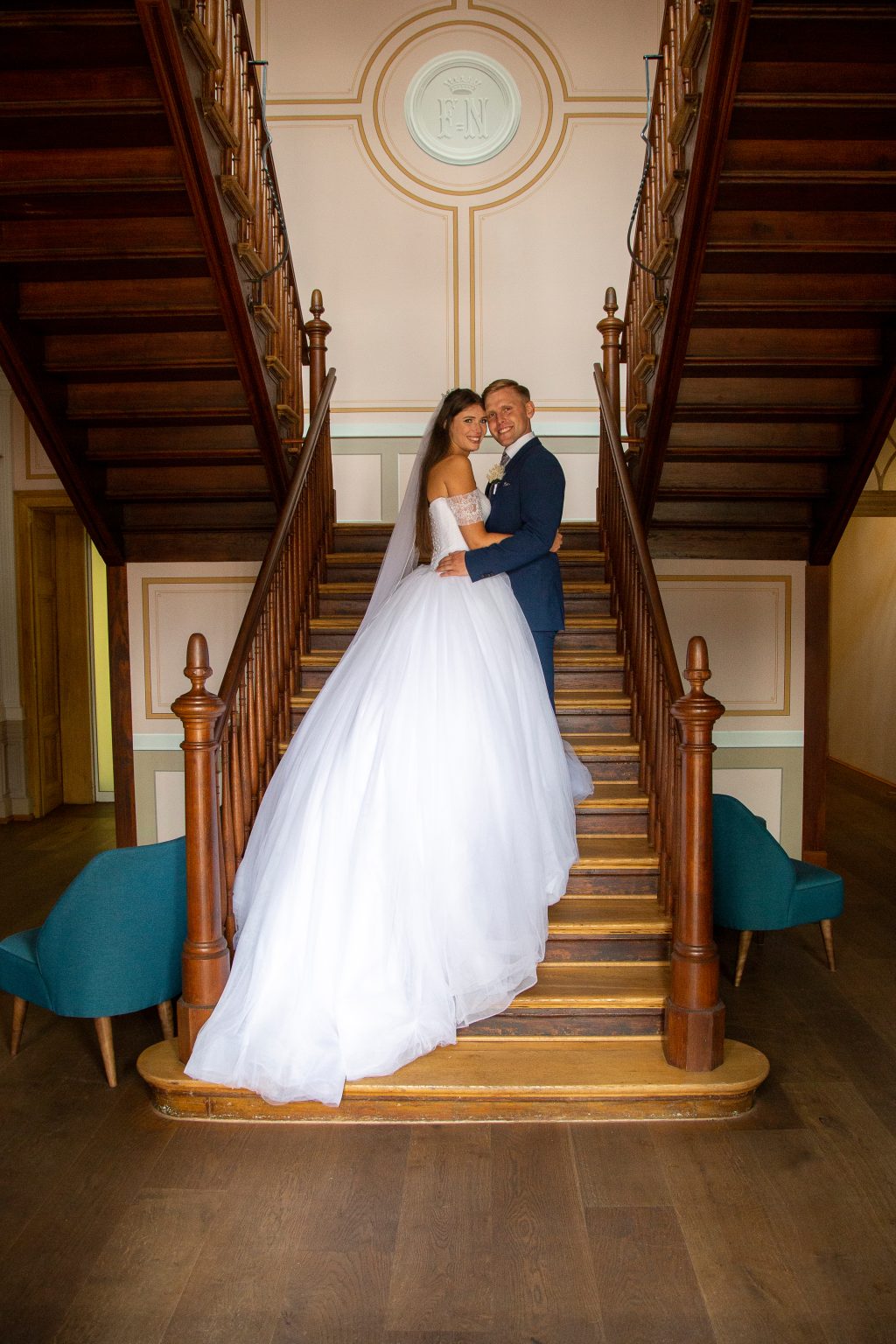 Hochzeitsfoto von Sarah Seiler Fotografie Ein Hochzeitspaar steht umarmt auf einer Treppe und Sarah Seiler Fotografie fotografiert sie.