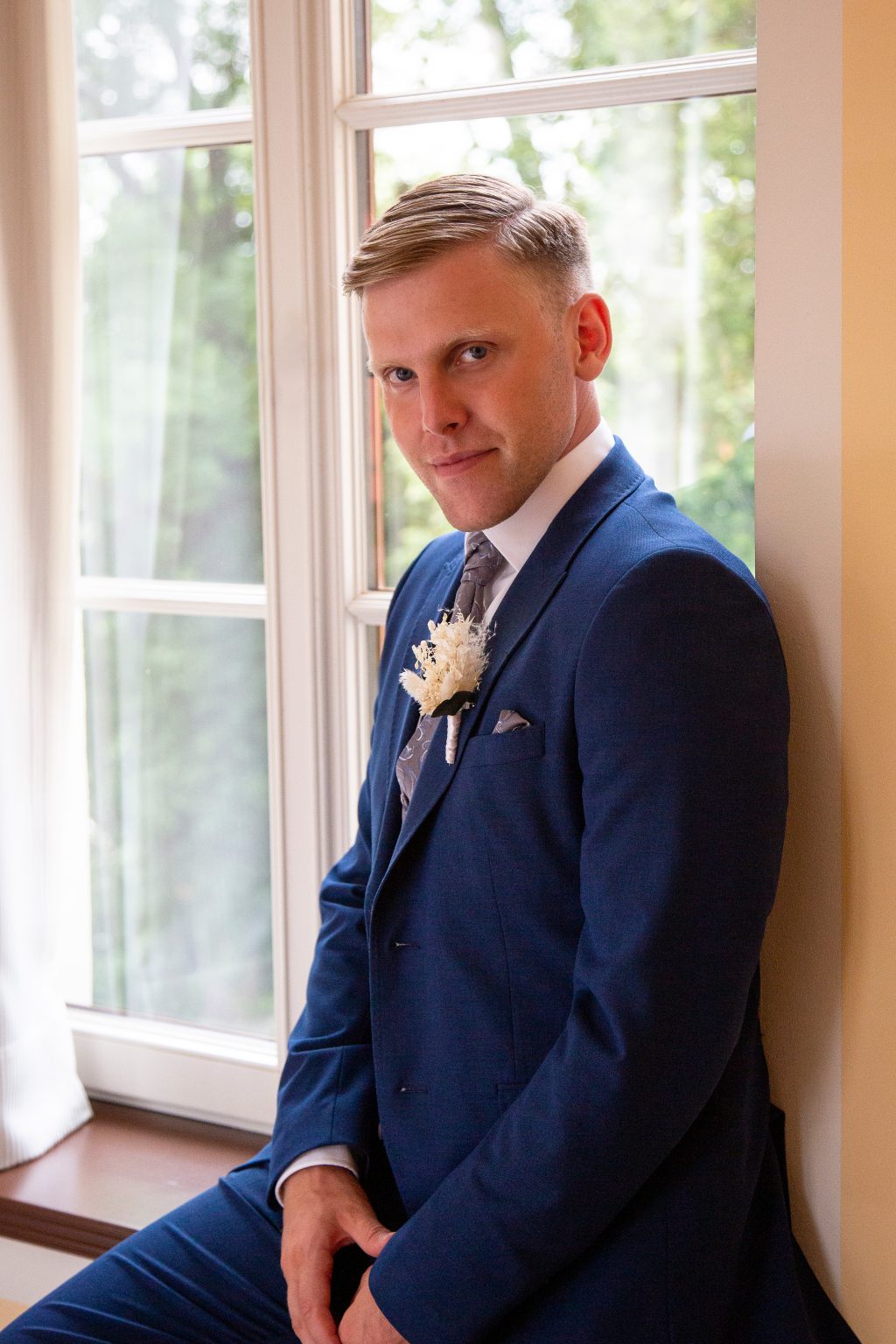 Hochzeitsfoto von Sarah Seiler Fotografie Ein Bräutigam steht am Fenster und Sarah Seiler Fotografie hält diesen Moment fest.