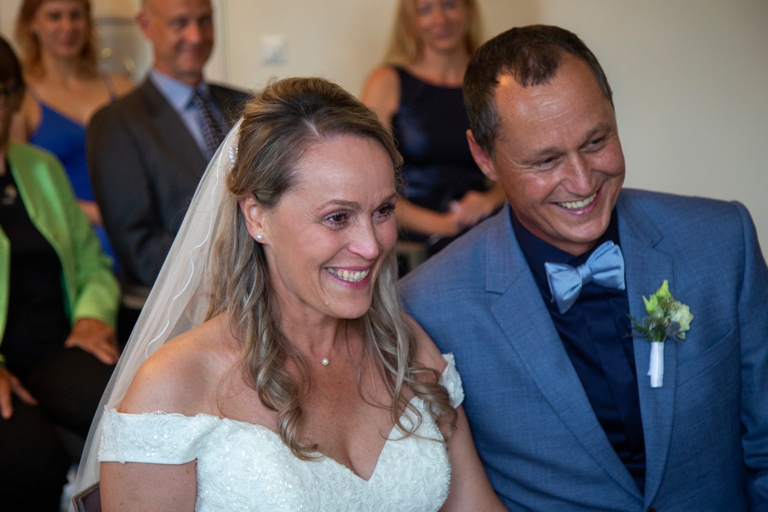 Hochzeitsfoto von Sarah Seiler Fotografie Eine Braut und ein Bräutigam lachen während der Trauung und Sarah Seiler Fotografie fotografiert sie.