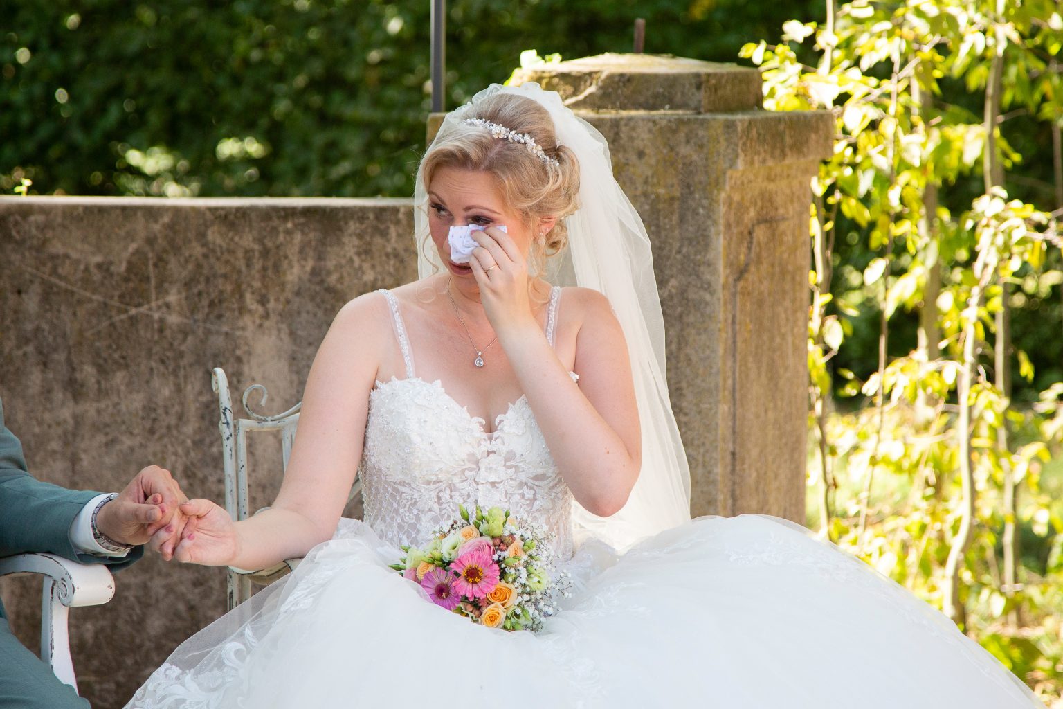 Hochzeitsfoto von Sarah Seiler Fotografie Eine Braut wischt sich eine Träne der Freude ab und Sarah Seiler Fotografie hält diesen Moment fest.
