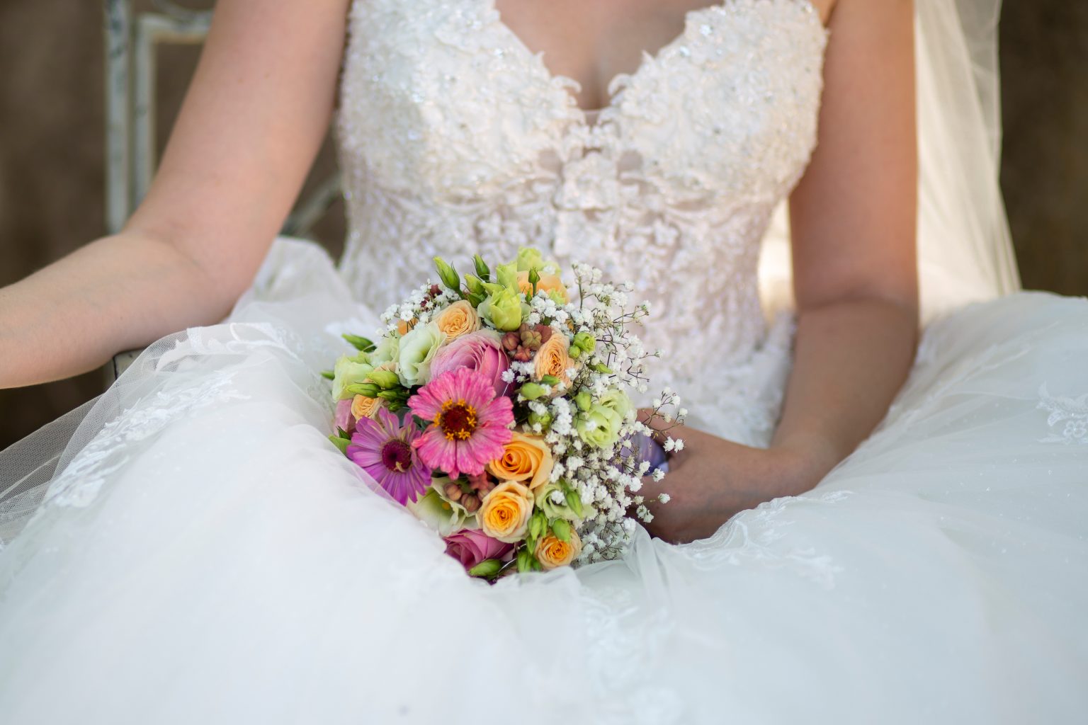 Hochzeitsfoto von Sarah Seiler Fotografie Eine Braut hält ihren Blumenstrauß und Sarah Seiler Fotografie fotografiert sie.