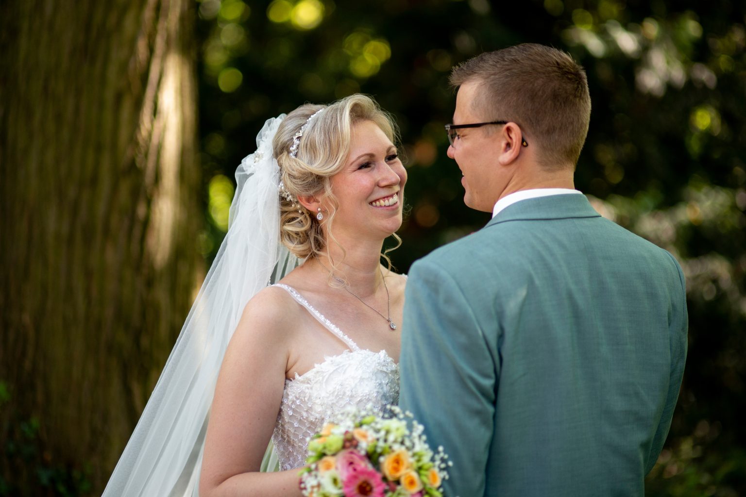 Hochzeitsfoto von Sarah Seiler Fotografie Ein Hochzeitspaar steht im Garten und Sarah Seiler Fotografie hält den Moment fest.
